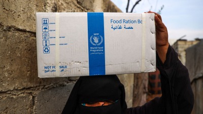 سيدة سورية تحمل سلة مساعدات في مخيم أطمة شمالي البلاد ـ AFP