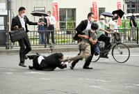 رجال الشرطة خلال إلقاء القبض على المشبته به في مقتل شينزو آبي (رويترز)