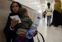 أم سورية تحمل طفلها الذي شُخصت إصابته بالكوليرا في مستشفى بمدينة الحسكة - 24 أيلول 2022 (رويترز)