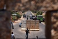 عناصر من قوات النظام يفتشون مدنيين على حاجز في درعا (أرشيفية/AFP)