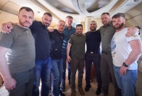 زيلينسكي يتوسط قادة كتيبة آزوف المفرج عنهم والذين رافقوه على متن الطائرة إلى أوكرانيا