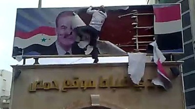 الشاب خضر الحمصي يمزق صورة حافظ الأسد المعلقة فوق نادي الضباط، حمص، جمعة العزة 25 آذار/مارس 2011 (يوتيوب)