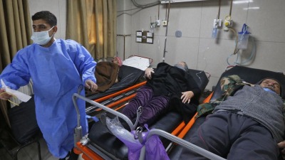 طبيب يقف إلى جانب عدد من المرضى في مشفى المواساة بدمشق (AFP)