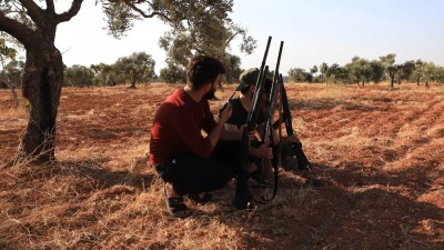 شبان سوريون يختبئون تحت أشجار الزيتون في قرية النيرب ويحملون بنادق الصيد ليدافعوا عن سماء منطقتهم عند قدوم أي مسيرة محملة بالمواد المتفجرة