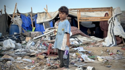 طفل فلسطيني وسط الدمار الذي سببه قصف إسرائيلي استهدف خياما للنازحين في ساحة مستشفى "شهداء الأقصى" بمدينة دير البلح، وسط قطاع غزة، 5 أيلول/يبتمبر 2024 (الأناضول)